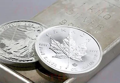 Zilverbaar van 1 kg en twee zilveren munten, waarvan een Canadese zilveren munt